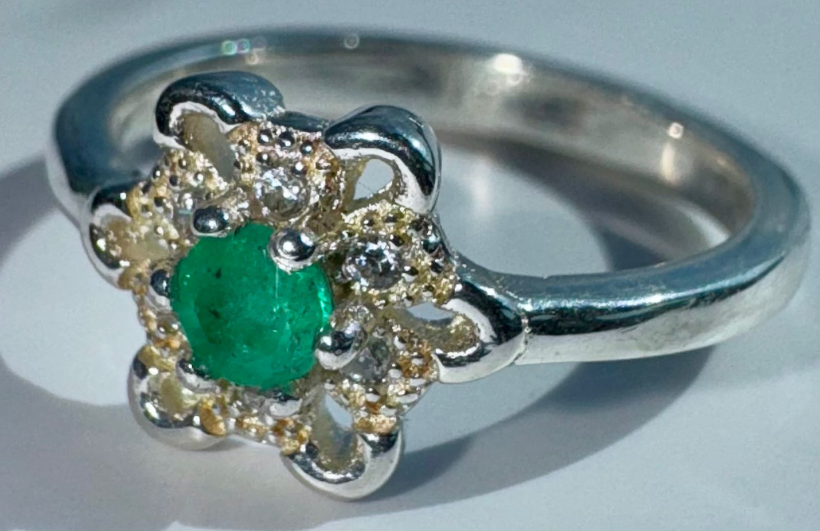 Anillo NOIRA en forma de flor de plata 925 con una esmeralda redonda natural colombiana de 3mm y 0.16ct. Talla 4.5 US